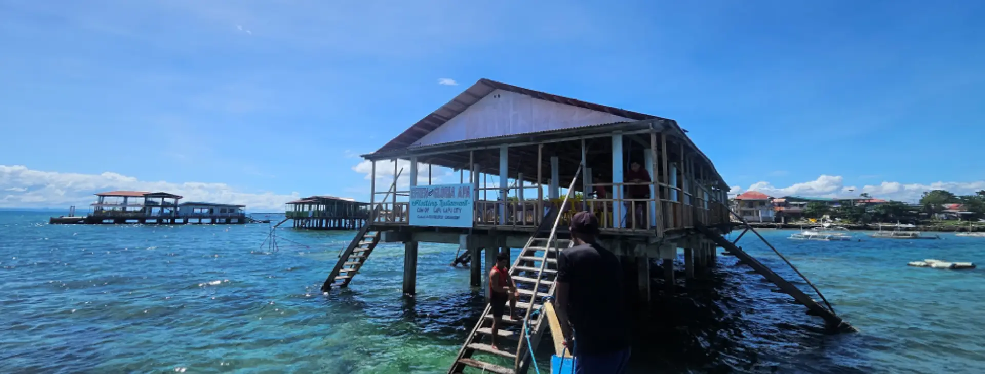 View from a private boat arriving at a rustic local floating seafood restaurant in Cebu