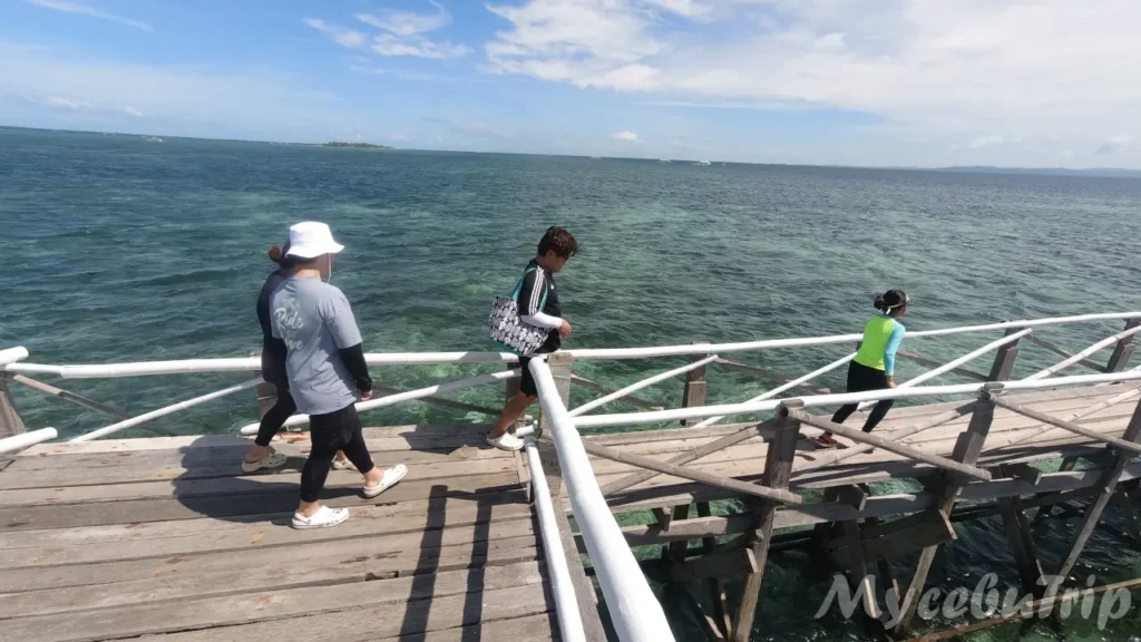 ナルスアン島の長い木の桟橋を歩く旅行者