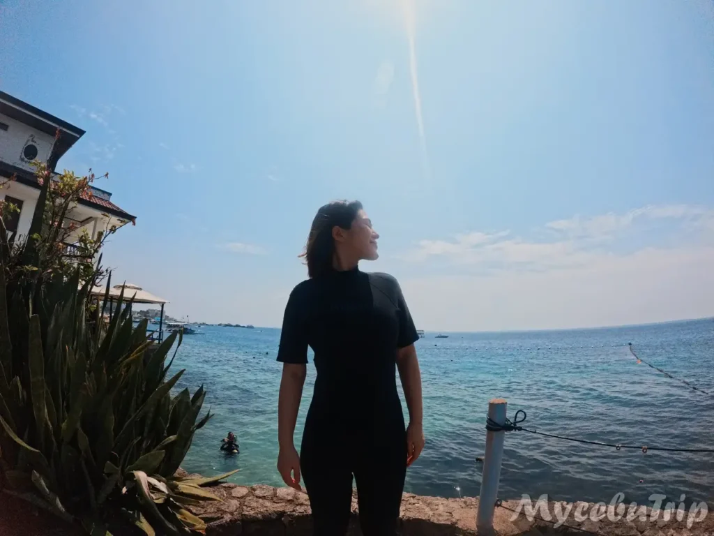 Female tourist standing by the water before her Discover Scuba Diving session
