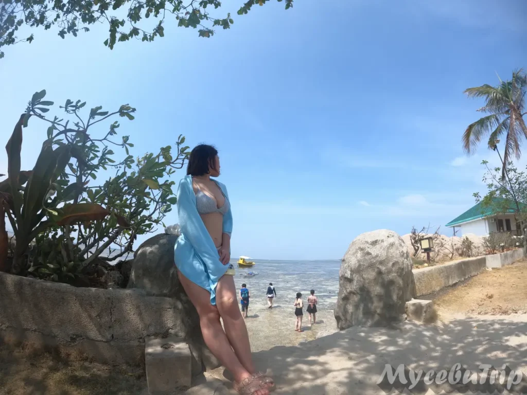 Female tourist looking out at Nalusuan Island's coastline